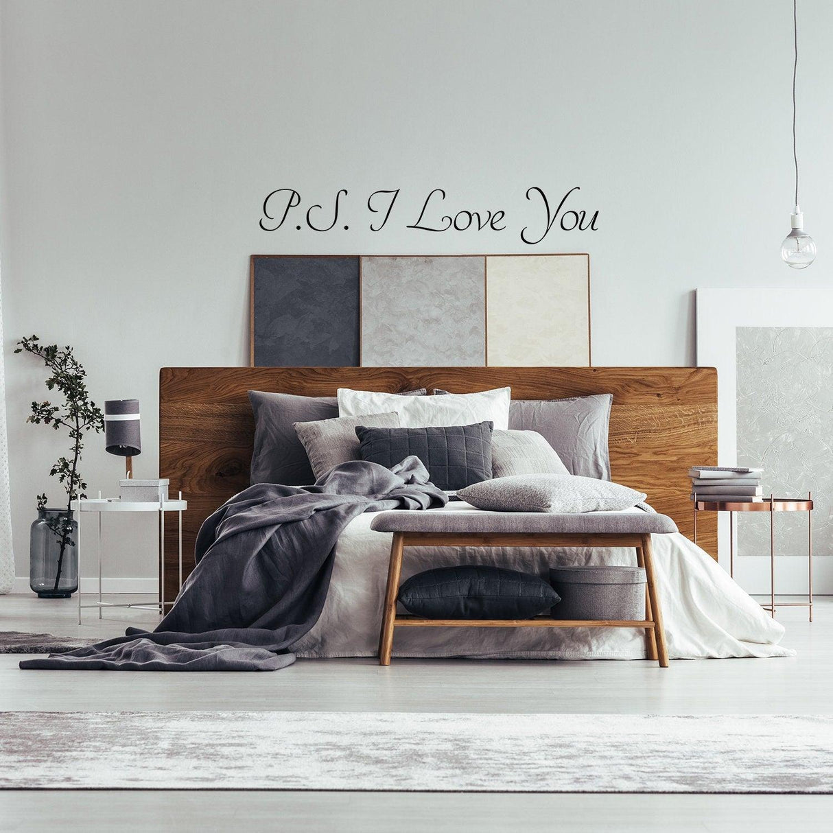 Romantic bedroom featuring a 'P.S. I Love You' wall sticker above a stylish bed with gray bedding and decor.