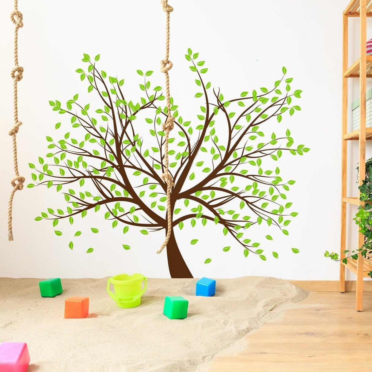 Tree sticker decal featuring brown branches and green leaves on a nursery wall, enhancing the playful decor.