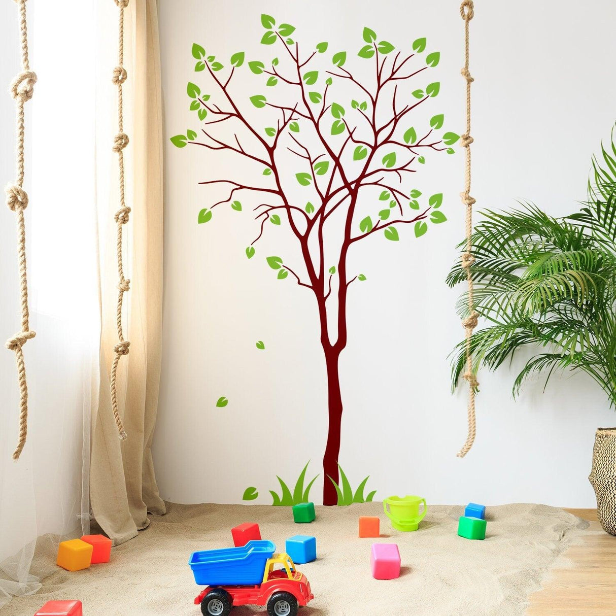 Tree sticker decal with green leaves on a nursery wall, creating a nature-inspired atmosphere.