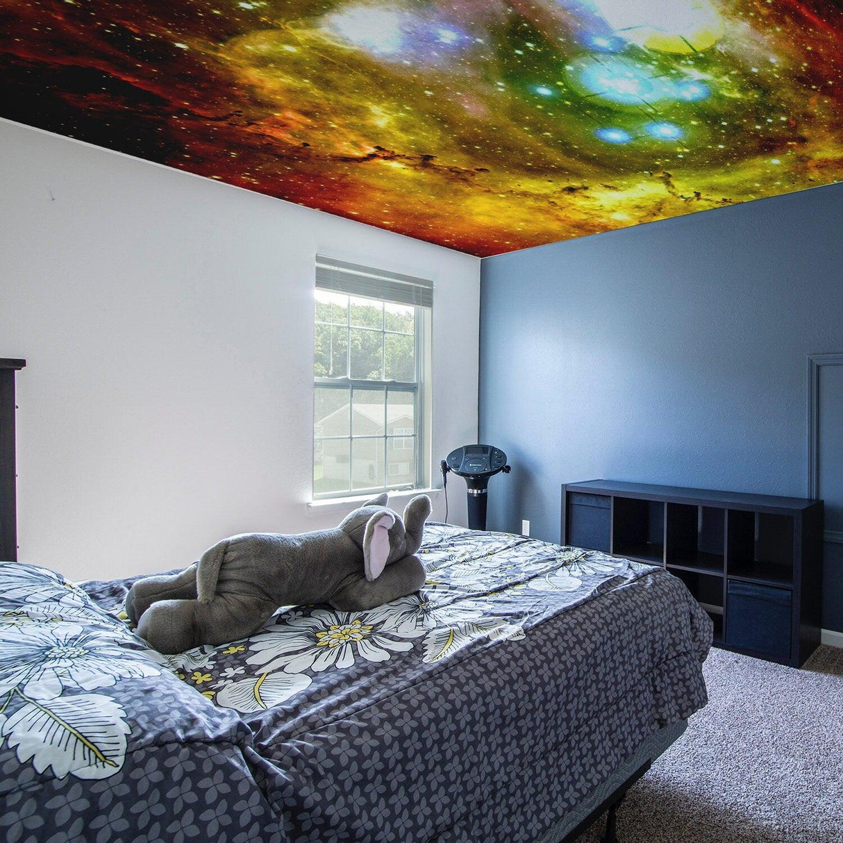 Space theme ceiling vinyl sticker in bedroom, featuring colorful galaxy design with stars and planets.
