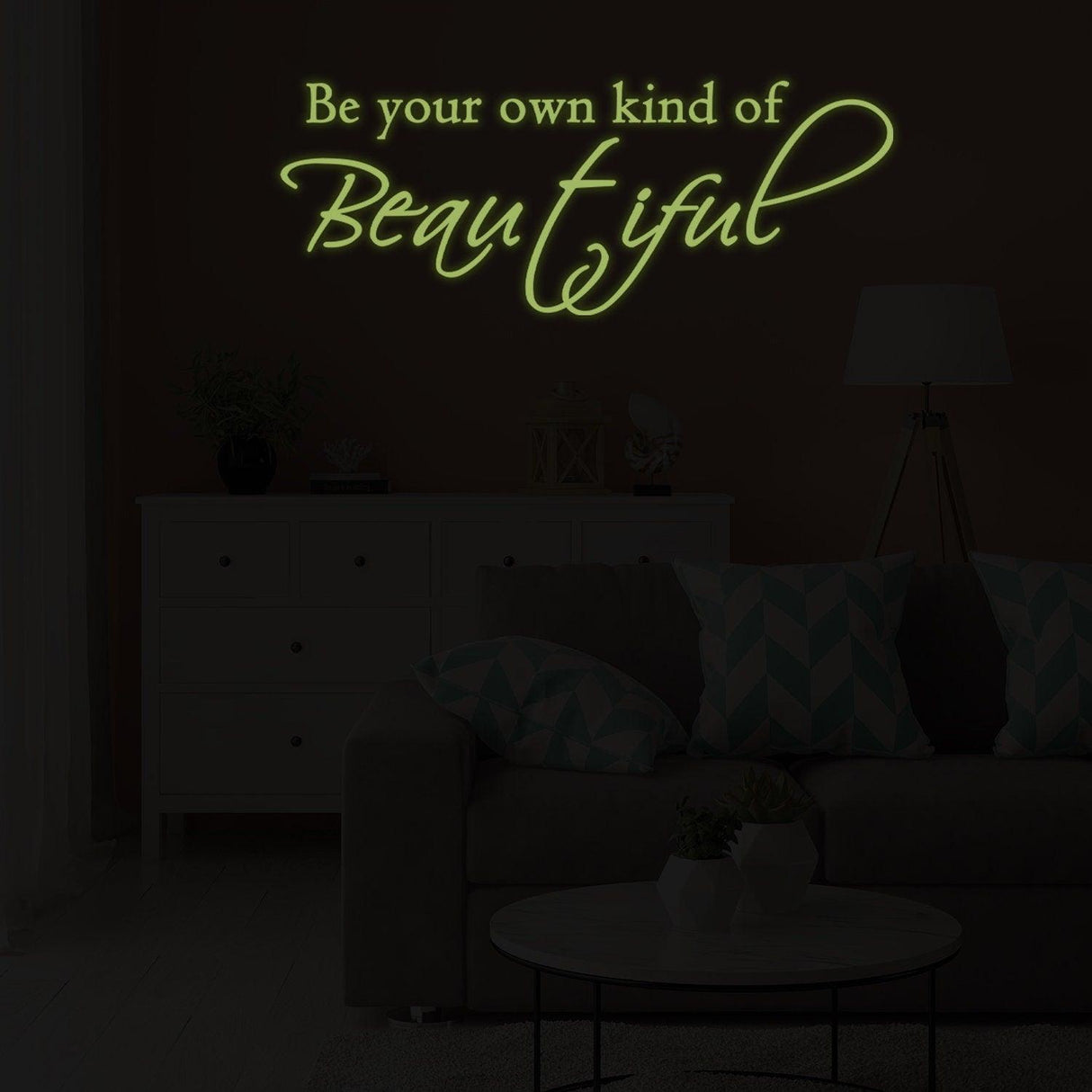 Glow in the dark wall sticker with the quote 'Be your own kind of Beautiful' in a cozy living room setting.