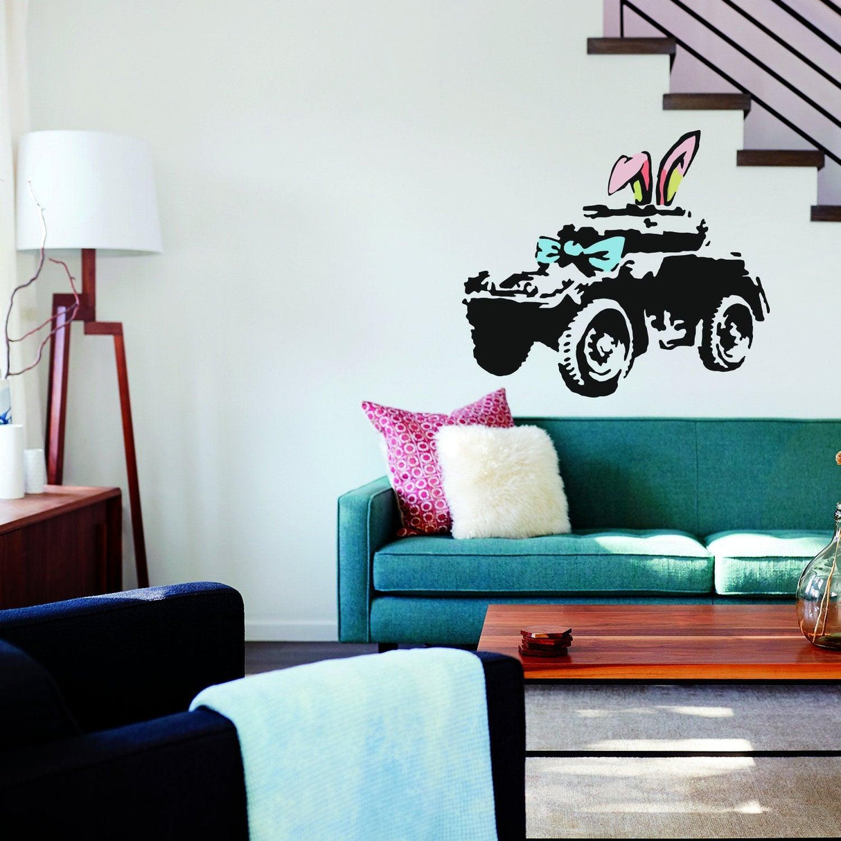Banksy-inspired armoured car wall art sticker with bunny ears and bow on a modern living room wall.