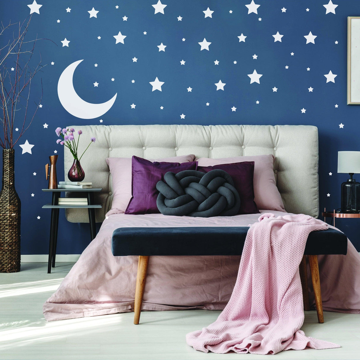 Cozy bedroom with navy star wall decals, white crescent moon, and plush bedding for whimsical home decor.