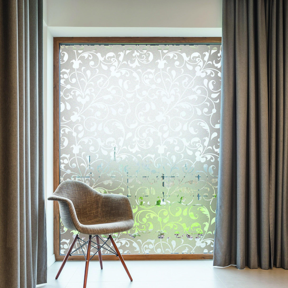Frosted window vinyl decal with elegant floral design, enhancing a bright indoor space with a chair and curtains.