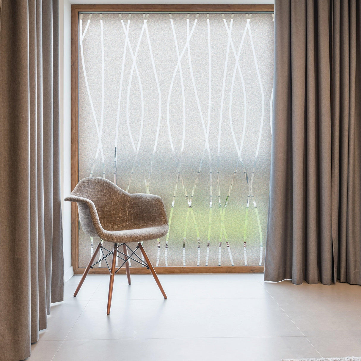 Stylish frosted glass window decal in a modern interior with a chair and elegant curtains.