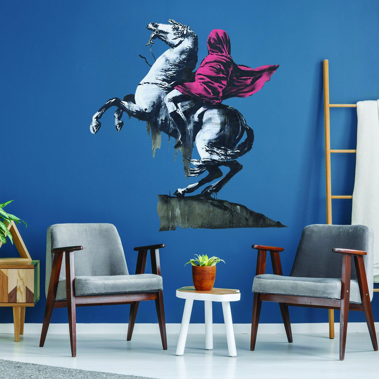 Banksy Napoleon vinyl wall sticker on blue wall, featuring Napoleon on horseback in a red hoodie for modern decor.