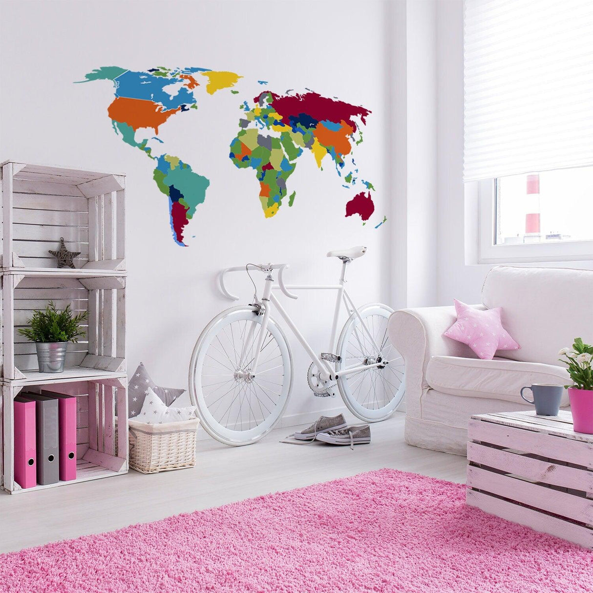 Colorful large world map wall decal in a modern living room with bike and pink rug, perfect for children's decor.