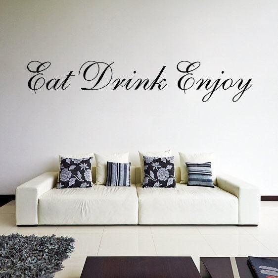 Stylish vinyl wall sticker saying 'Eat Drink Enjoy' above a modern white sofa with decorative pillows.