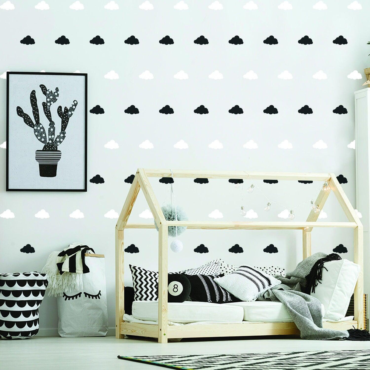 Stylish nursery with cloud wall decals, cozy bed, and modern decor, creating a whimsical baby room atmosphere.