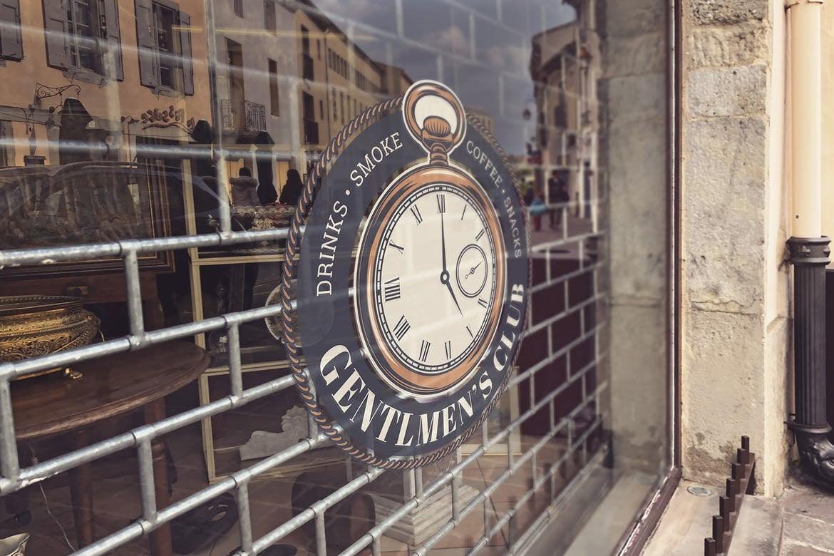Sign on window for a Gentlemen's Club, featuring drinks, smoke, and coffee themes with an ornate clock design.