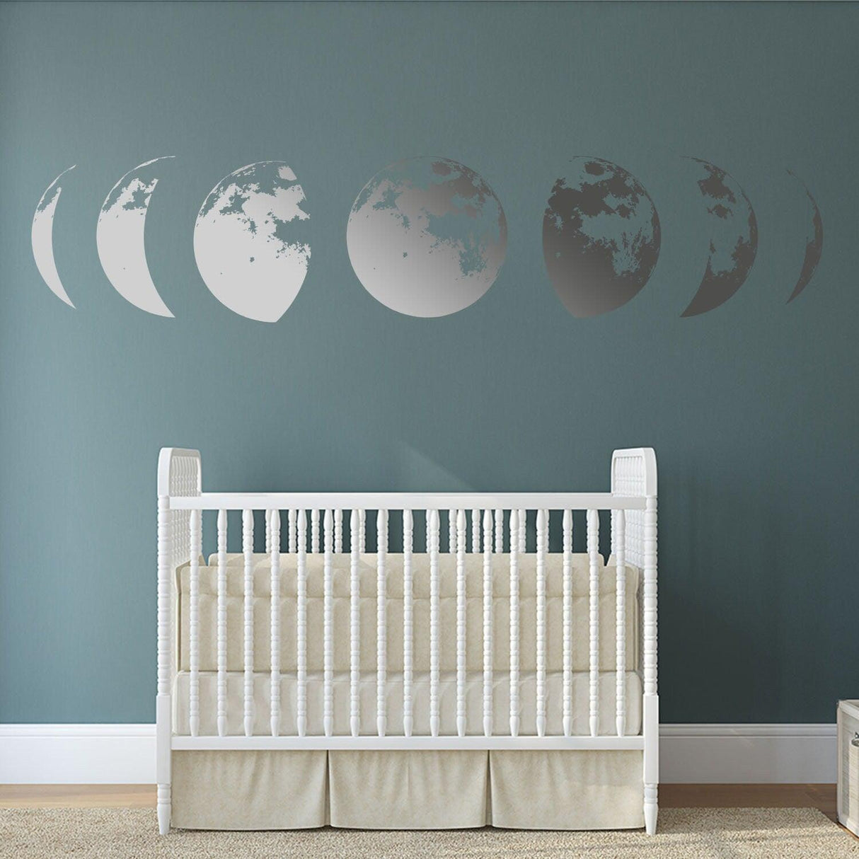 Moon phases wall decal in a nursery, adding elegance to the decor with a calming design on a blue wall.