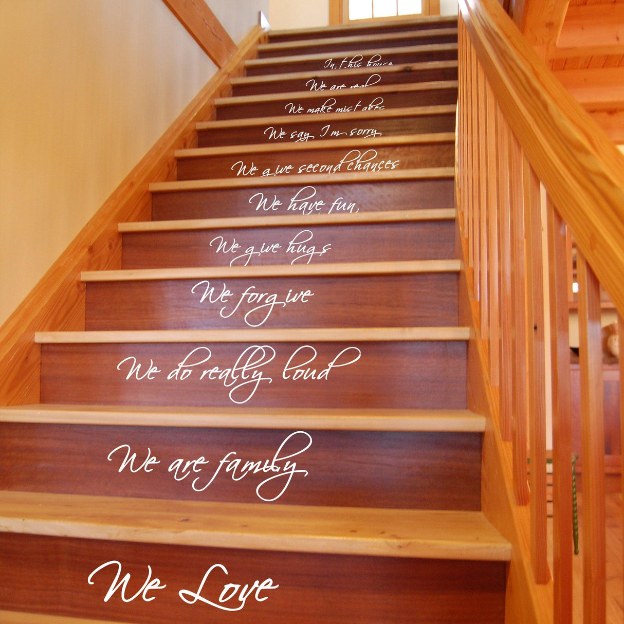 Stairs with 'In this house' quote decals showcasing family values and love in a warm home setting.