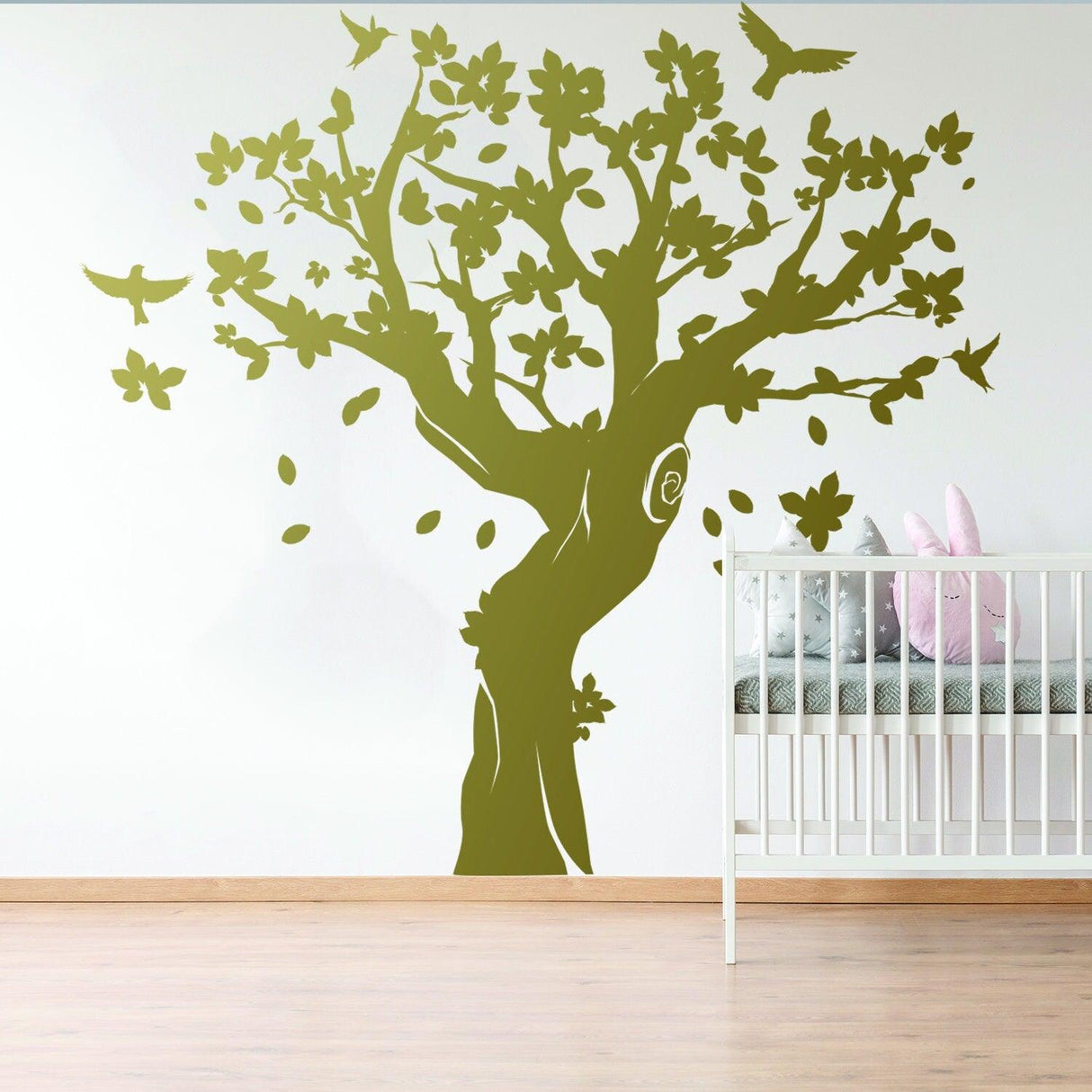 Large tree wall decal in a nursery, featuring birds and leaves, adding charm to the kids' room decor.