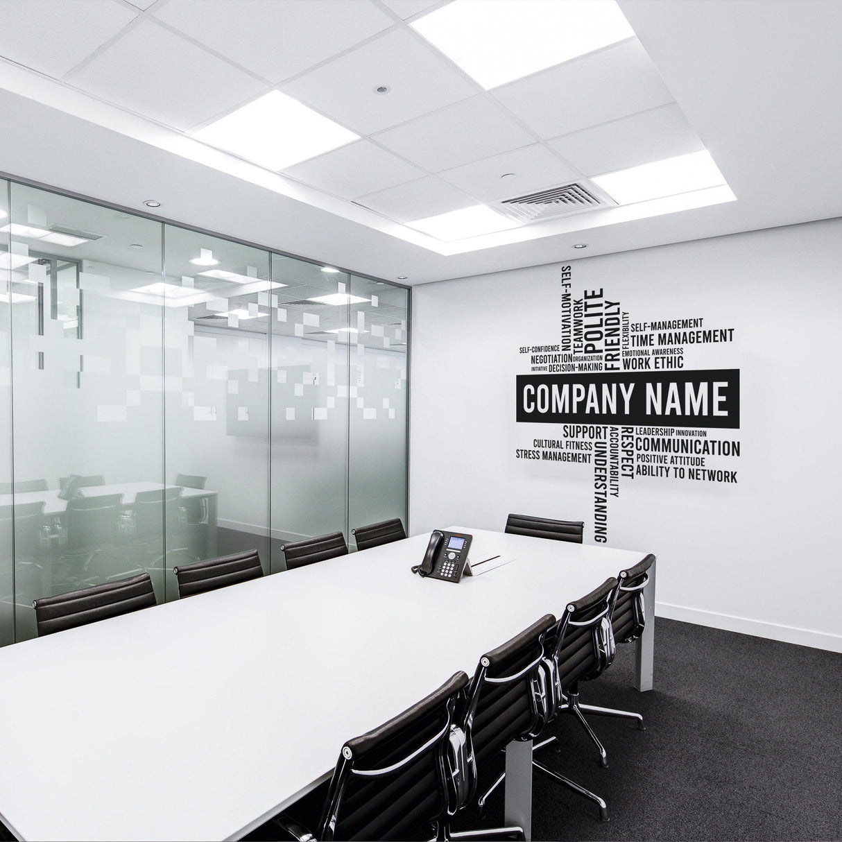 Modern office meeting room featuring a custom vinyl wall sticker with company name and motivational keywords.