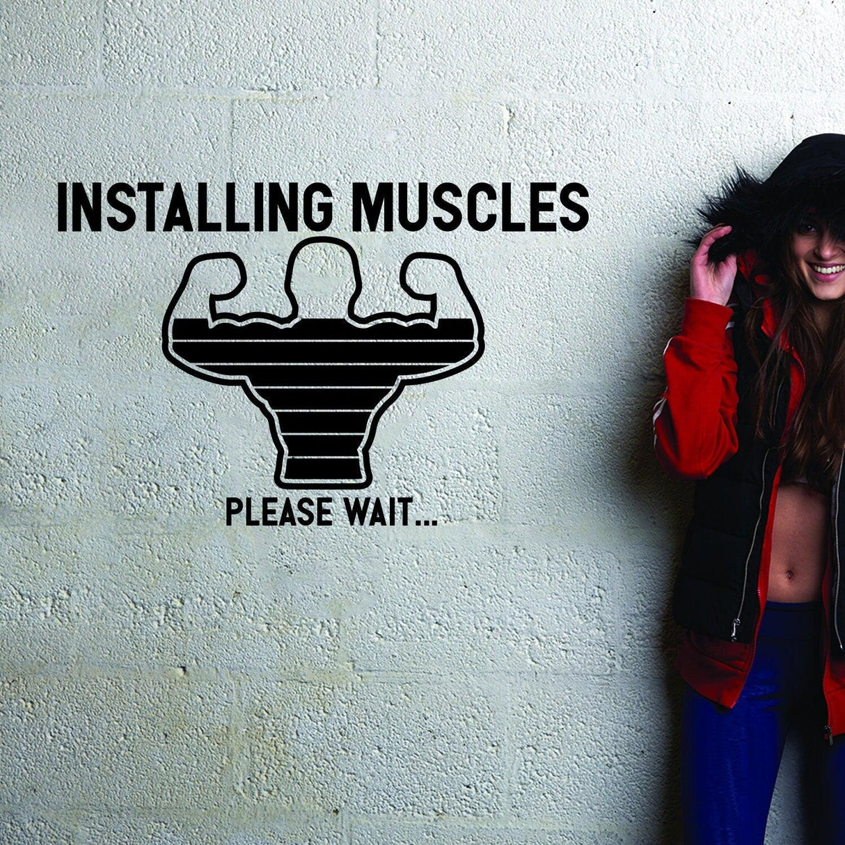 Vinyl decal with text 'Installing Muscles Please Wait...' and muscle graphic on a textured wall.