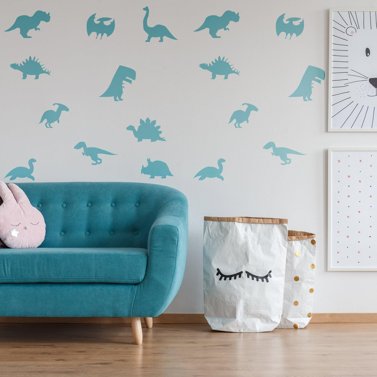 Dinosaur silhouette wall decals in a nursery, featuring various dino designs above a teal couch and playful storage bins.