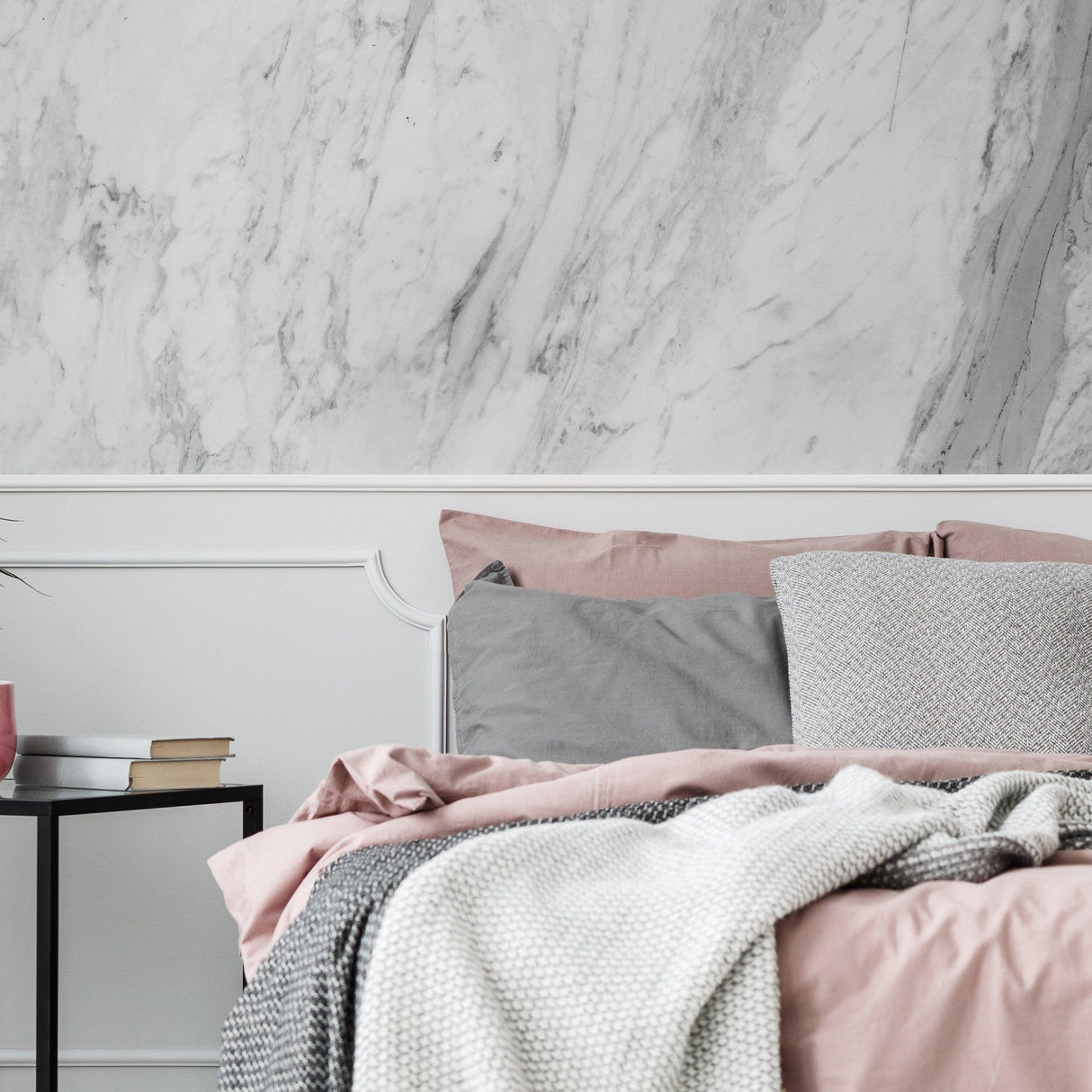 Elegant bedroom featuring marble vinyl wallpaper and a cozy bed with pink and gray bedding.