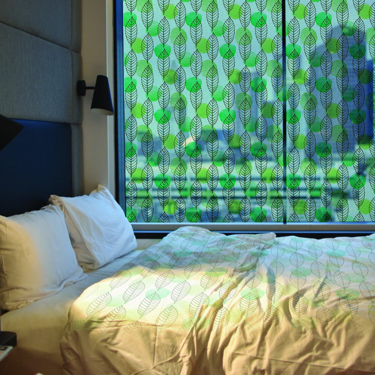 Leaf pattern privacy film covering a window in a cozy bedroom, enhancing elegance and privacy.