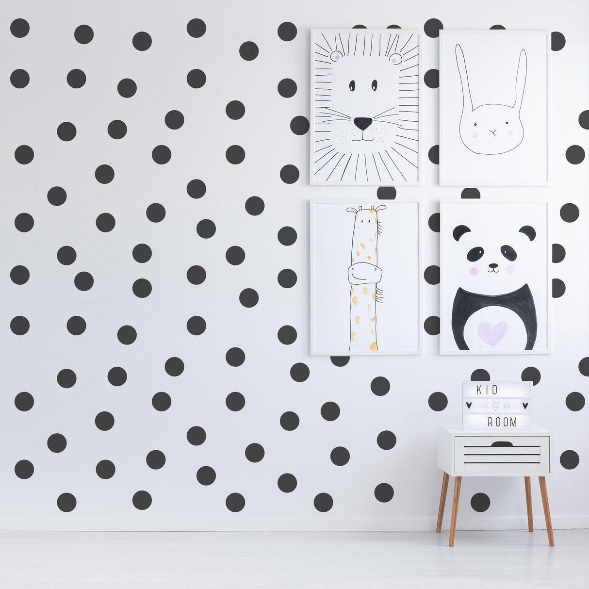 Black 2-inch round dot wall stickers on white wall with playful animal art and a modern storage unit.