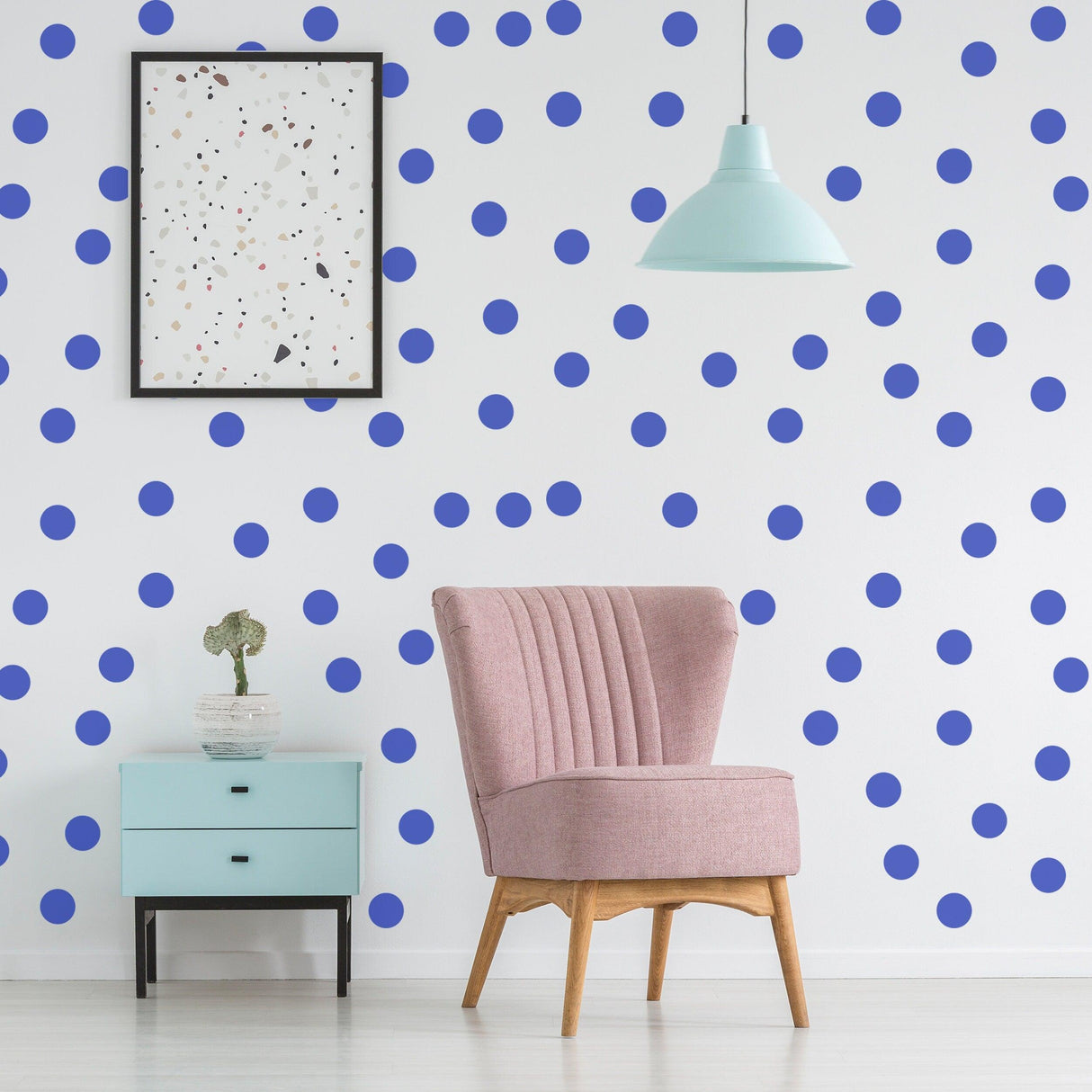 Blue circle wall stickers on white wall with pink chair and light fixture, creating a vibrant and artistic room decor.