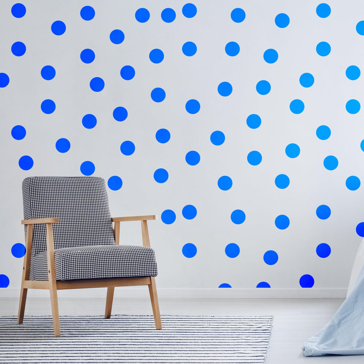 Blue circle wall stickers on a white wall, with a stylish chair in the foreground, adding color to the room.