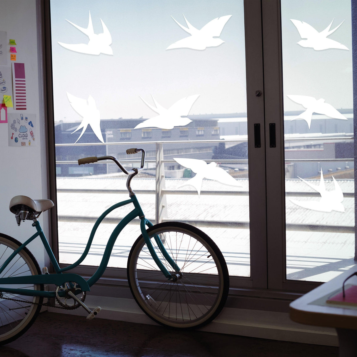Window decal bird strike stickers with frosted design preventing collisions, displayed on glass door near a bicycle.