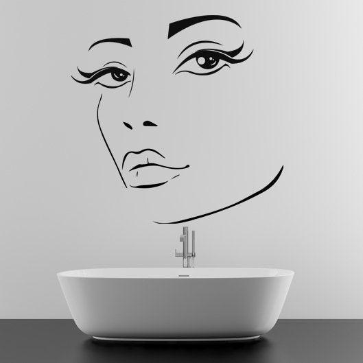 Beautiful wall sticker of a woman's face above a modern bathtub, enhancing feminine decor in a bathroom.