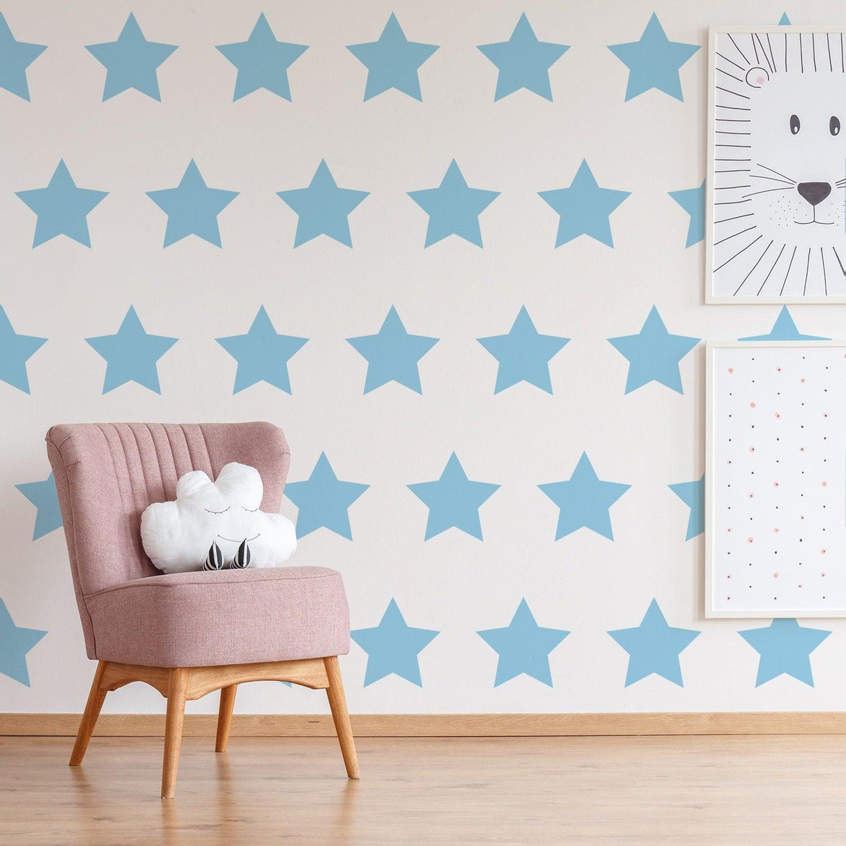Nursery decor featuring removable blue star wall decals, pink chair, and playful wall art.