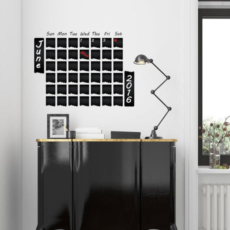 Weekly planner chalkboard wall sticker displayed on a wall above a stylish black cabinet.