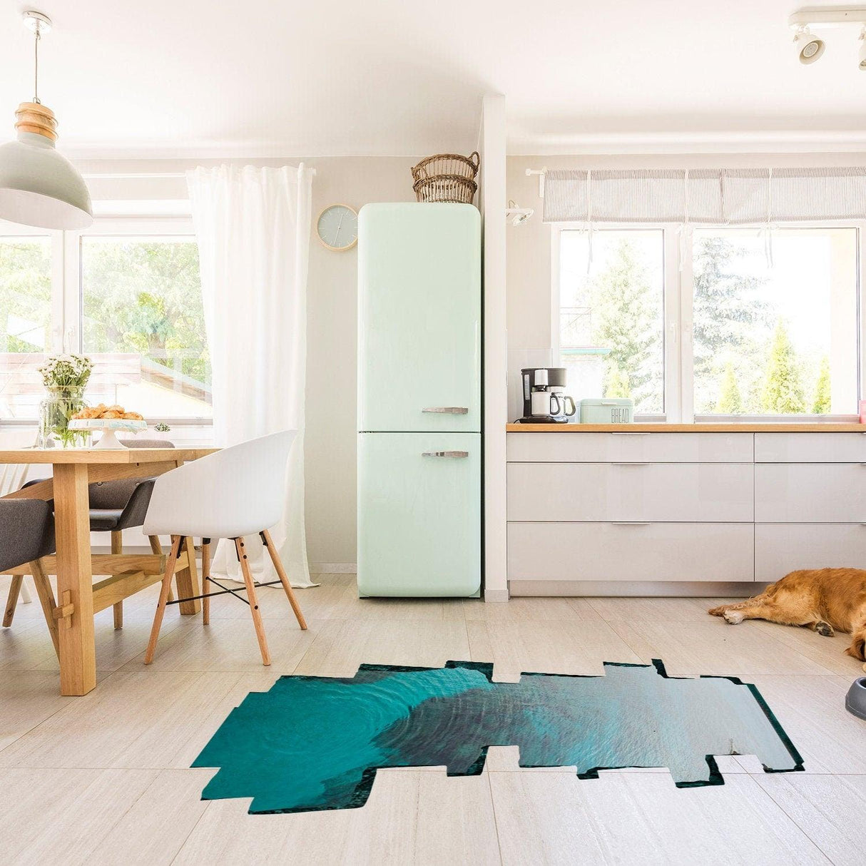 3D ocean floor decal in a modern kitchen with light wood furniture and a dog resting on the floor.