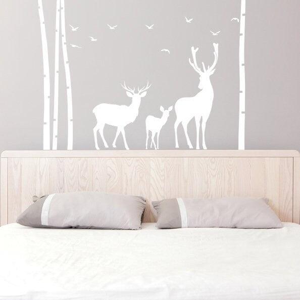 Deer and moose wall decal in a birch tree forest above a bed, perfect for nursery or kids room decor.