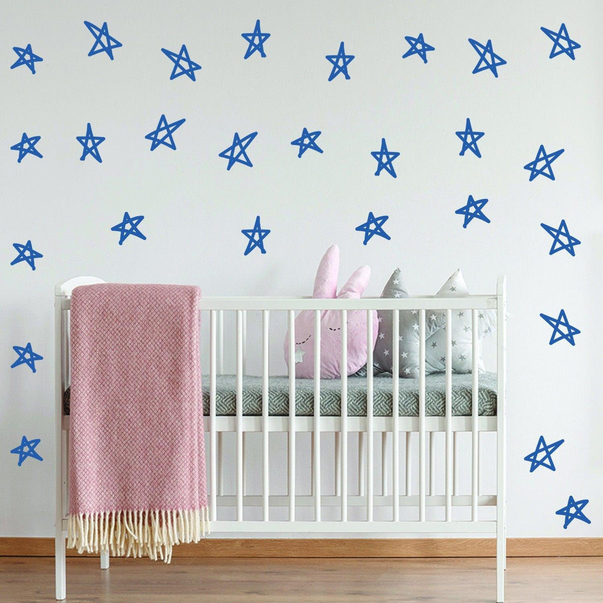 Blue star wall decals applied in a nursery with a crib, adding charm and whimsy to the child's room.