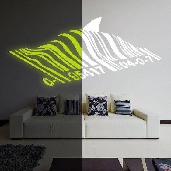 Glow in the dark Banksy Barcode Shark wall vinyl sticker displayed on a modern living room wall.