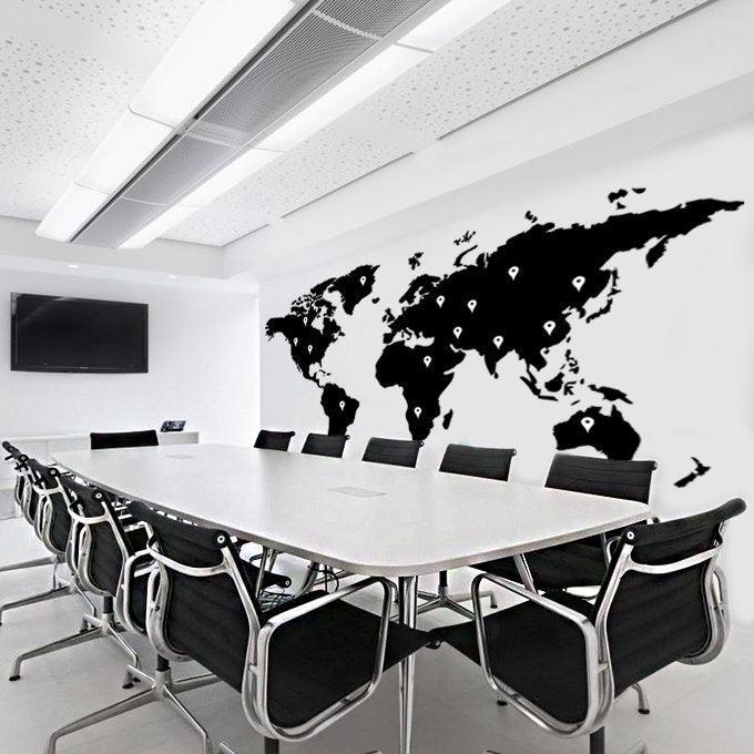 Large black world map wall decal in modern conference room, adding a stylish touch to the decor.