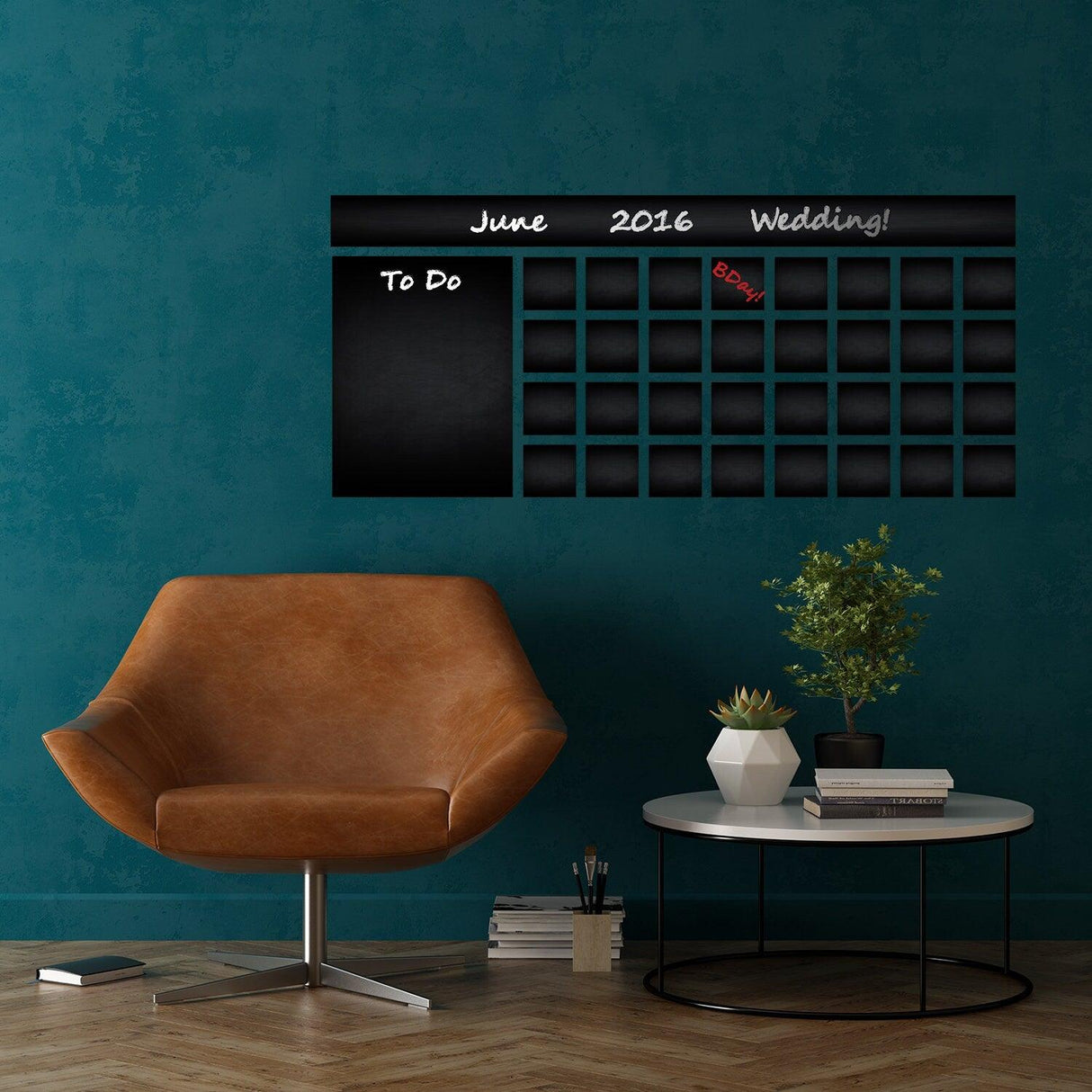 Wall weekly planner chalkboard decal displayed in a styled room with a modern chair and plant.