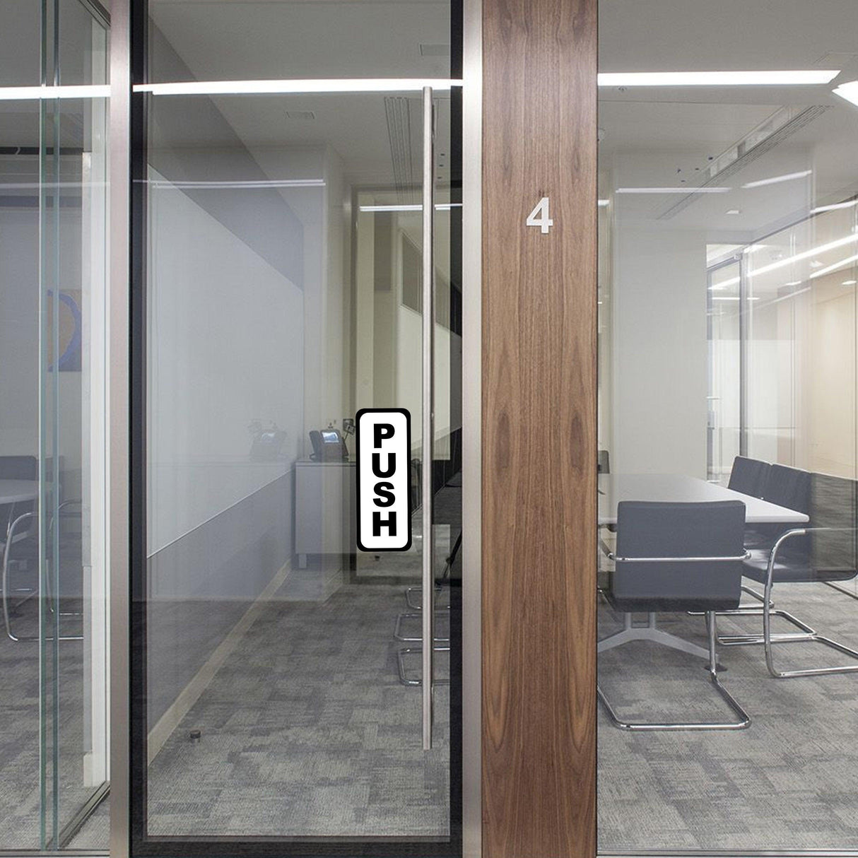 Vertical 'PUSH' door sign on glass office door for easy navigation.