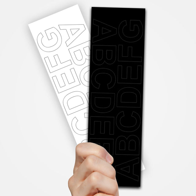 Hand holding black and white vinyl removable letter stickers featuring alphabet design for easy labeling.