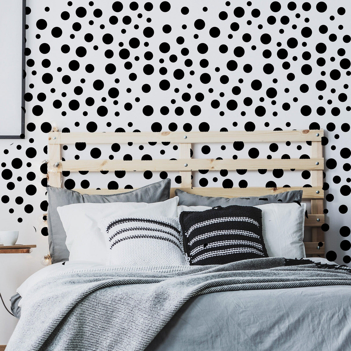Polka dots wall decals in a modern bedroom, featuring black circle vinyl stickers on a white wall.