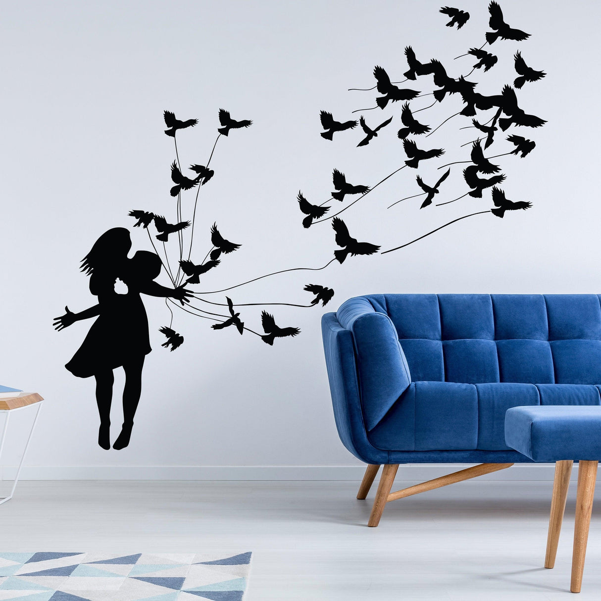 Silhouette of a girl surrounded by flying birds, creating a whimsical wall art scene in a modern living room.