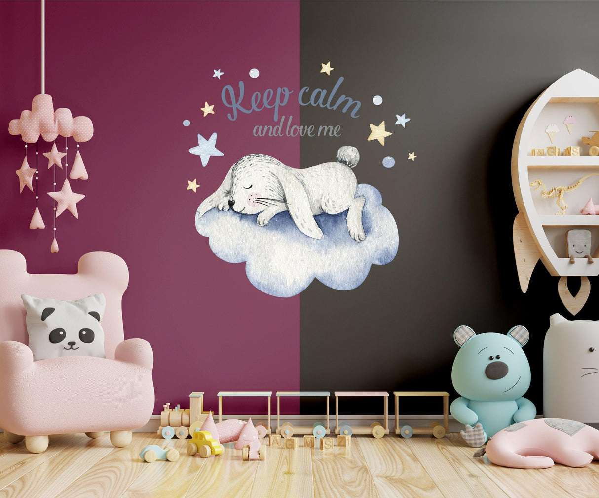 Whimsical baby nursery wall decor sticker featuring a sleeping bunny on a cloud with stars, adding charm to any child's room.