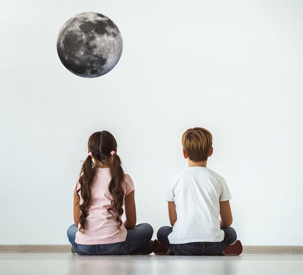 Children admiring a Full Moon Wall Sticker decal on a bright wall, showcasing the moon's realistic details.