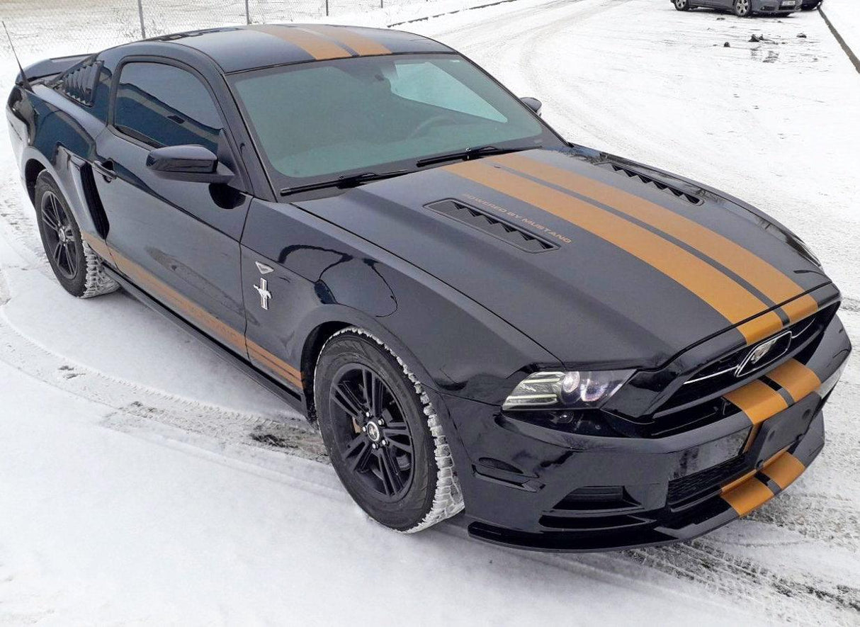 Black car with two orange racing stripes parked on snowy ground, showcasing sporty vinyl decals for RT models.