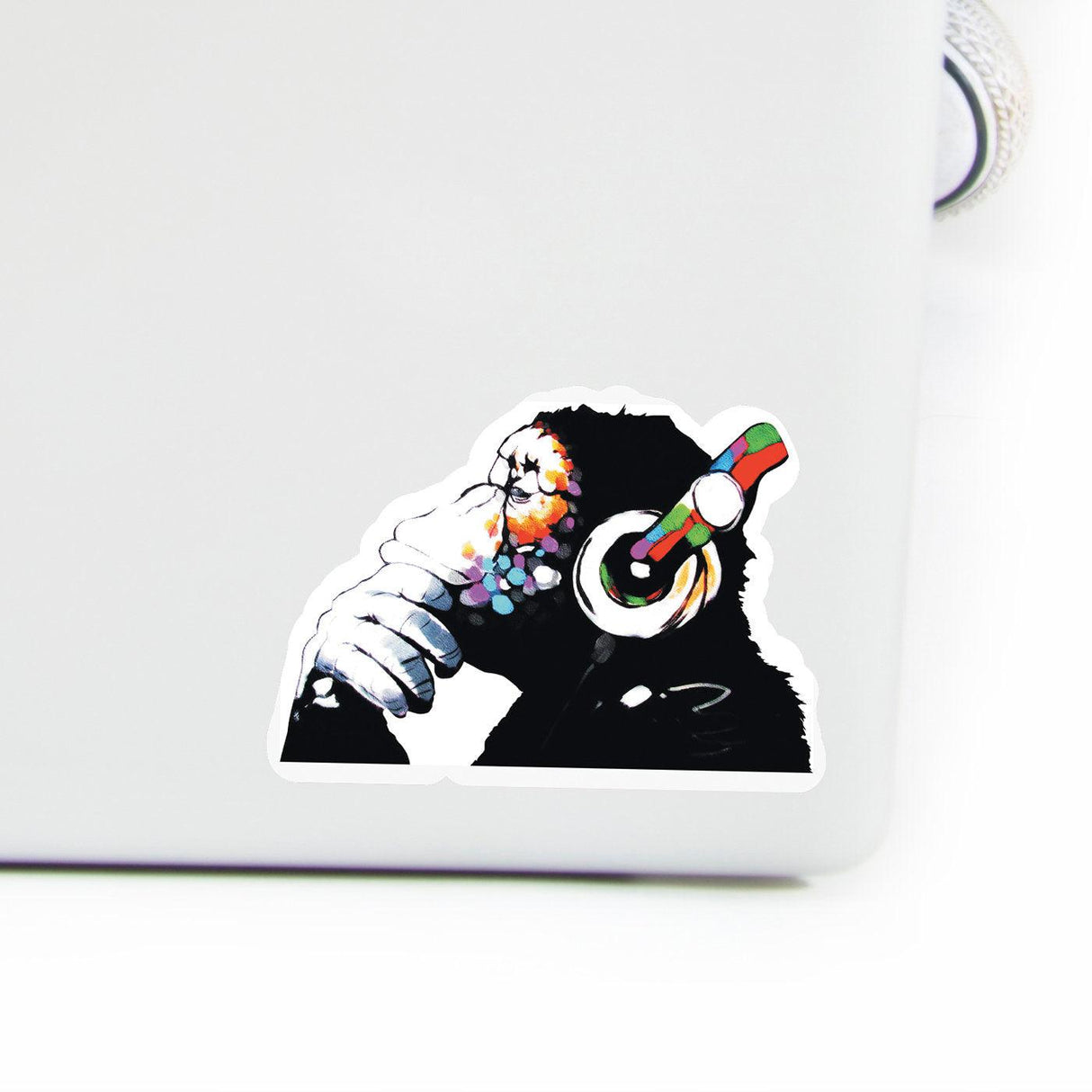 Colorful vinyl decal of a monkey with headphones, adding a playful touch to a laptop surface.