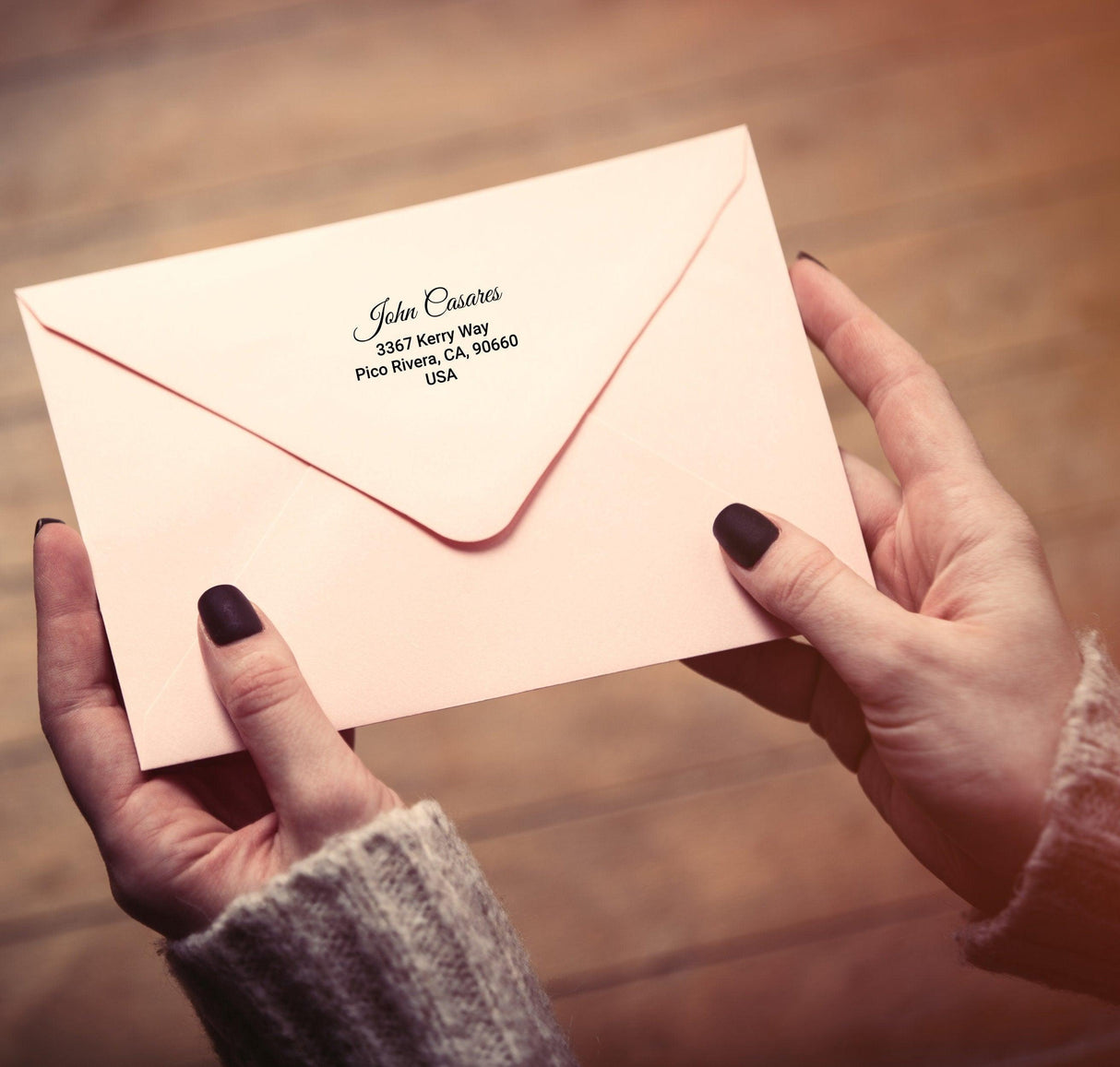 Person holding a pink envelope featuring Custom Clear Address Labels with personalized address details.