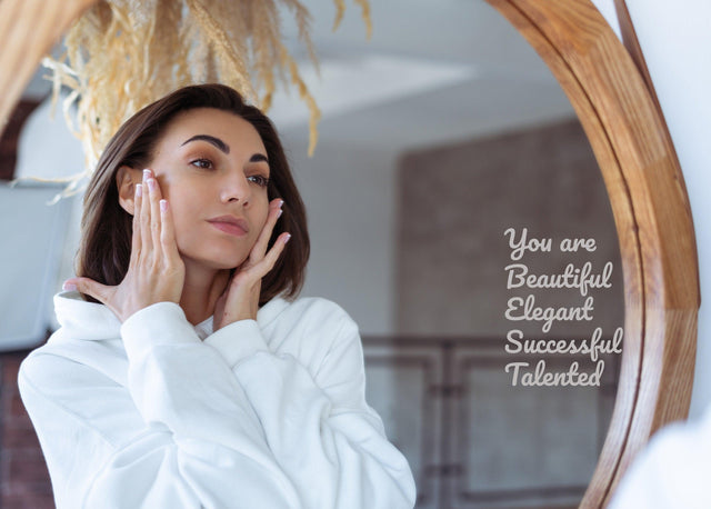 Woman admiring herself in a mirror with a motivational quote decal that says 'You are Beautiful, Elegant, Successful, Talented'.
