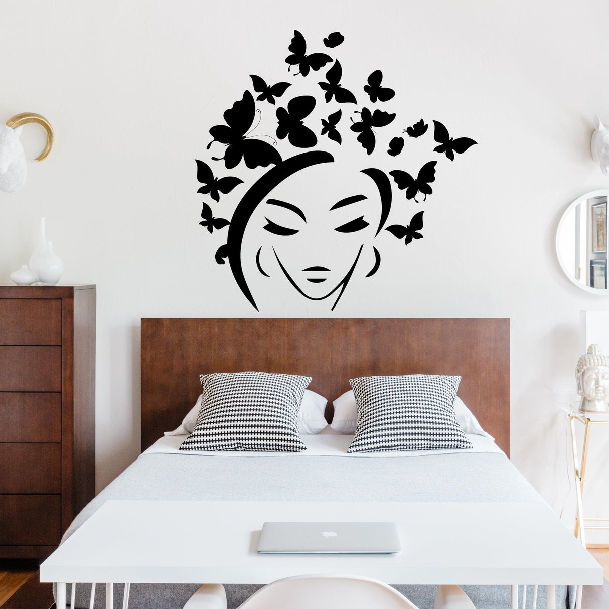 Butterfly wall sticker featuring a woman's face and butterflies above a stylish bedroom with modern decor.
