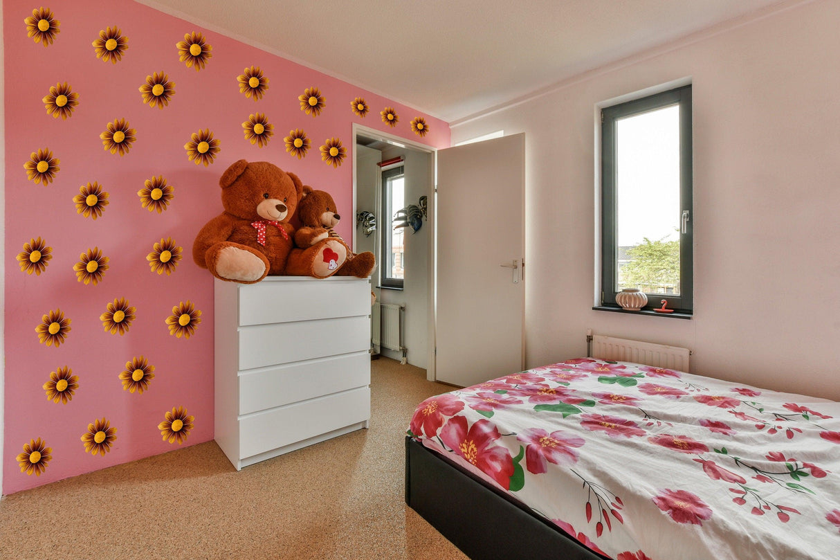 Cozy bedroom featuring pink walls adorned with sunflower wall stickers, cute teddy bears, and floral bedding.
