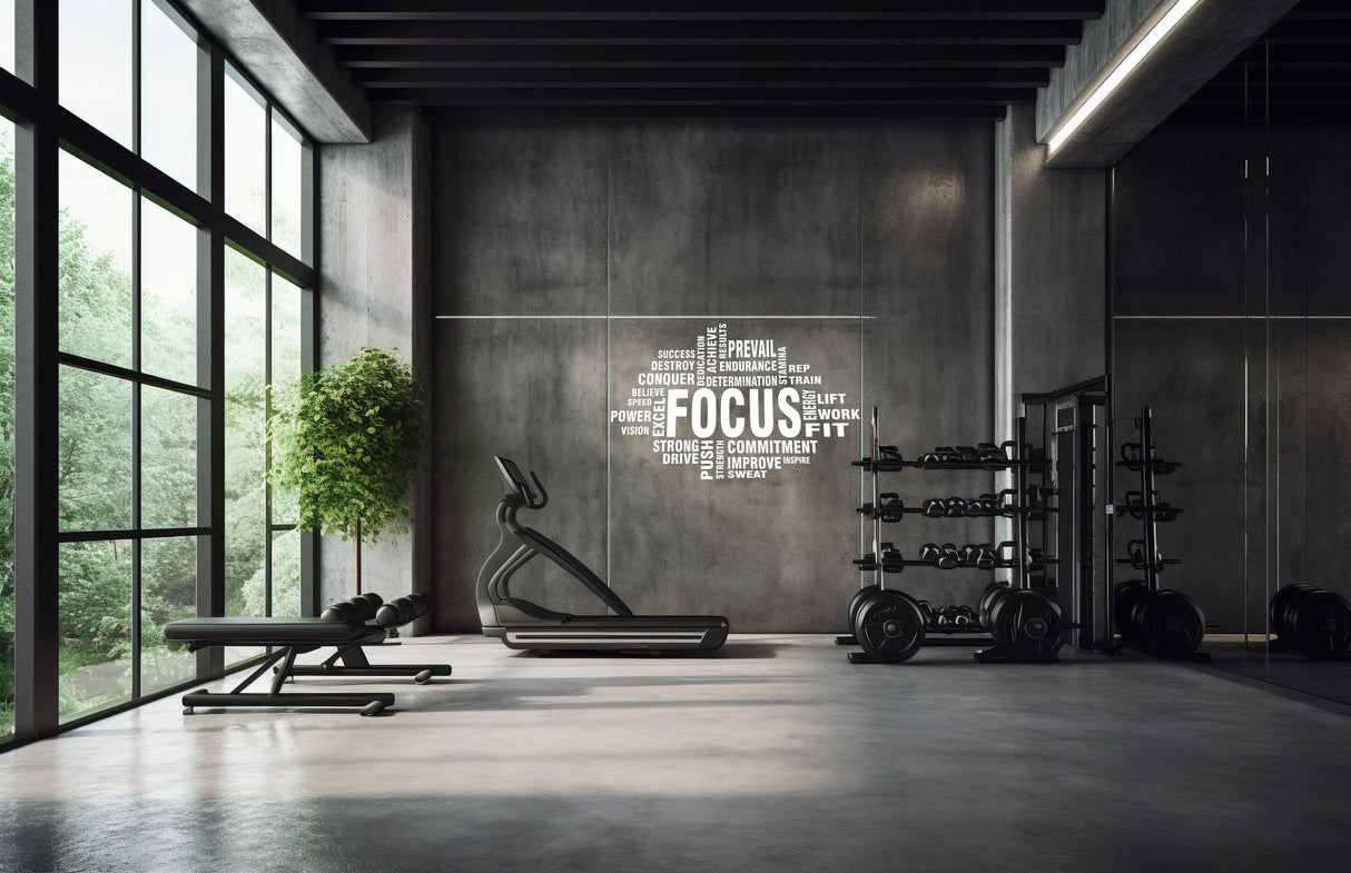 Motivational gym wall decal with the word 'FOCUS' and fitness terms in a modern home workout space.