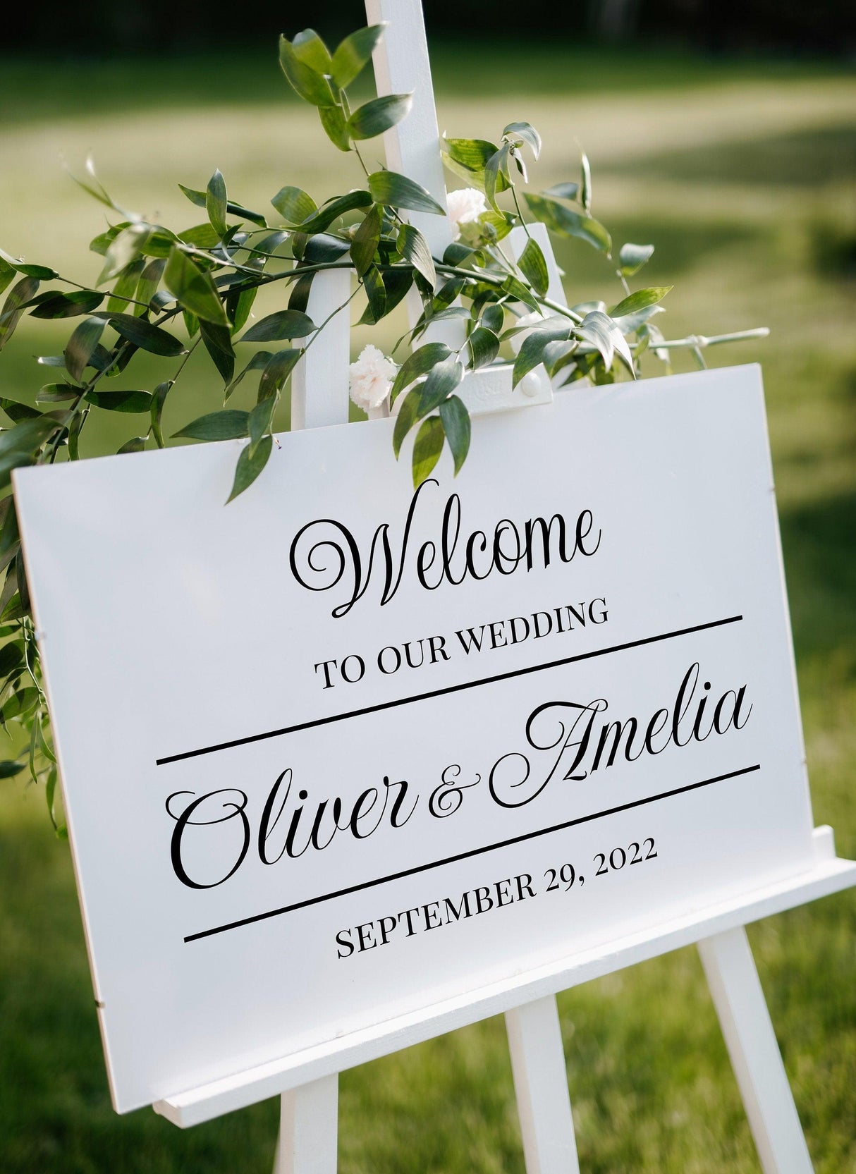 Personalized wedding welcome sign with names Oliver & Amelia, date September 29, 2022, elegantly displayed outdoors.