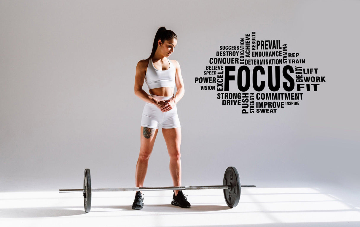 Motivational gym wall decal with focus quote and fitness terms, woman with barbell in home gym